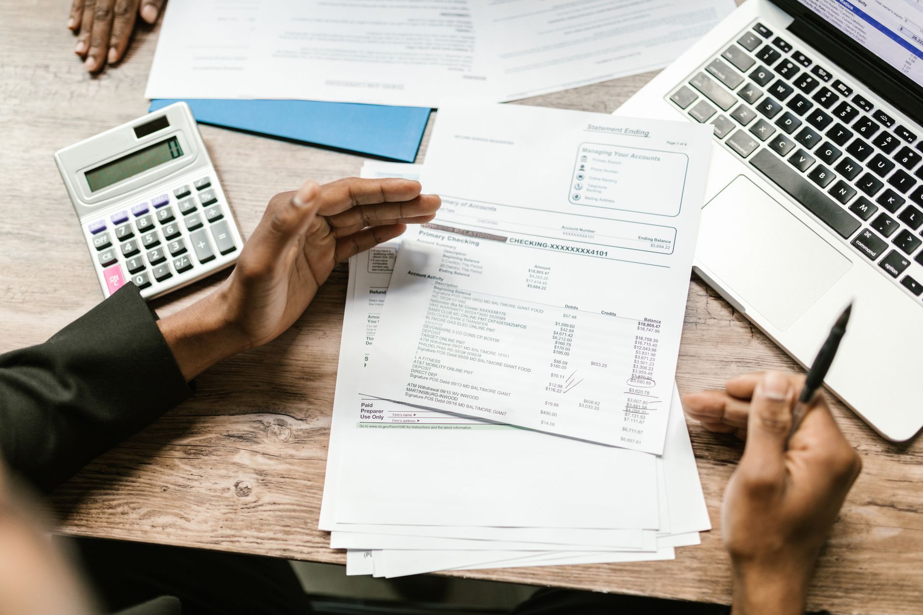 Landlord reviewing tax documents with calculator and laptop on desk