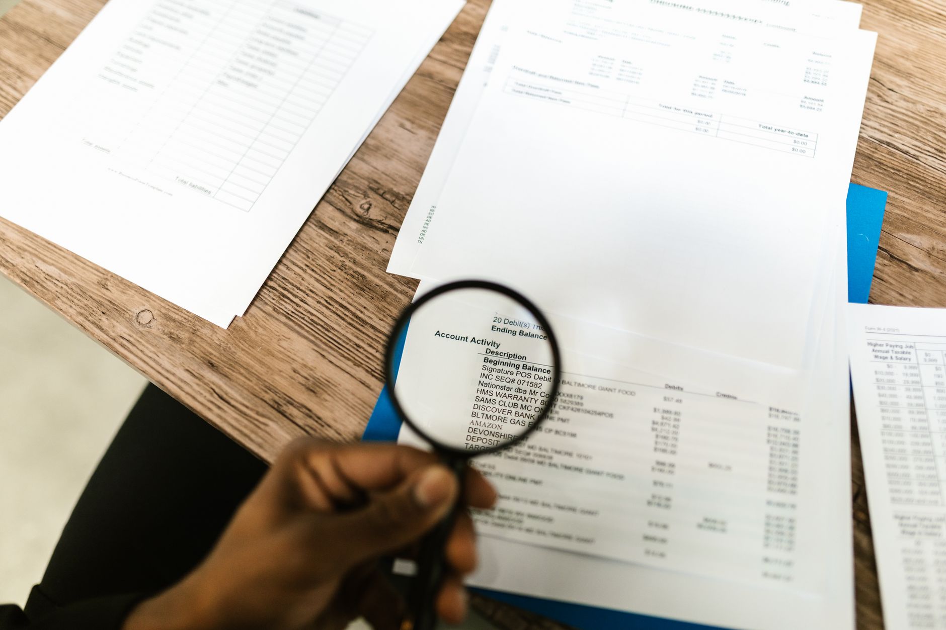 Professional reviewing property documents with magnifying glass