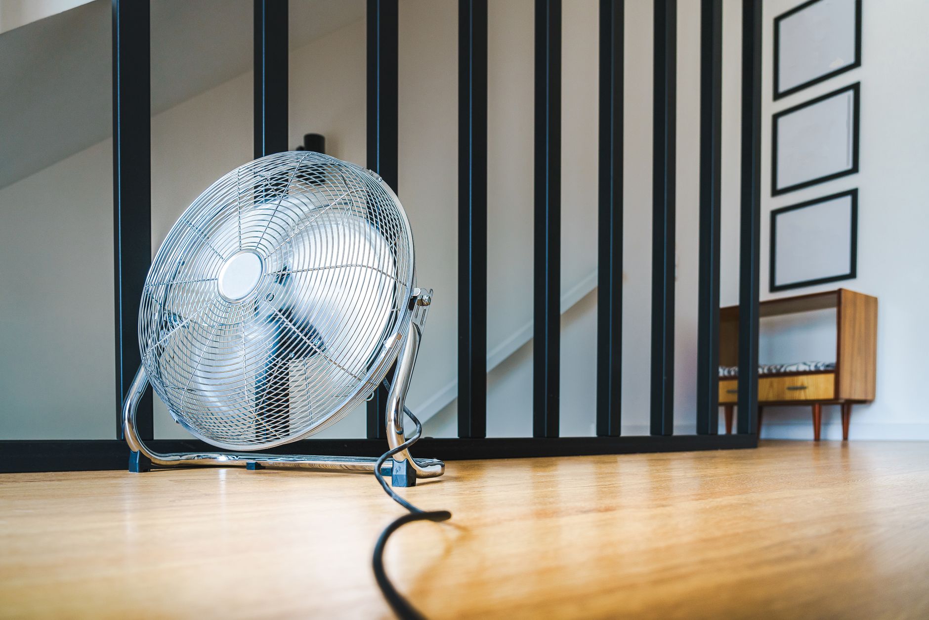 Social housing resident using fan during heatwave
