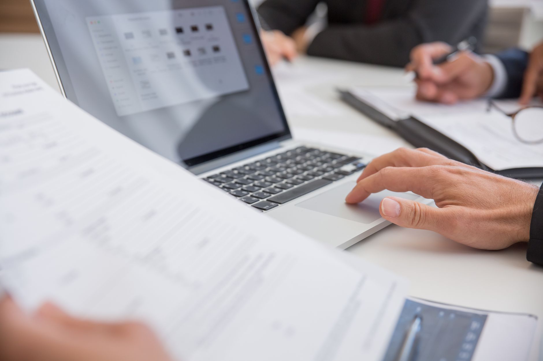 Landlord reviewing property portfolio documents on laptop