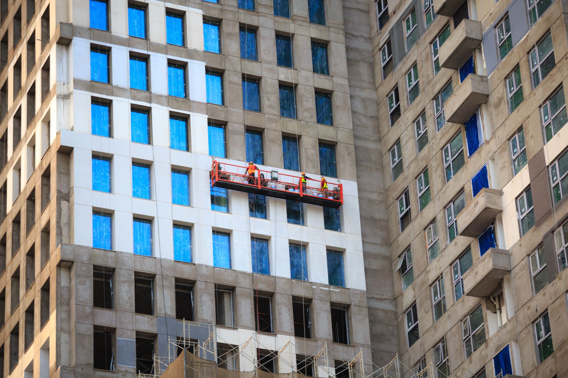 Construction workers removing unsafe cladding