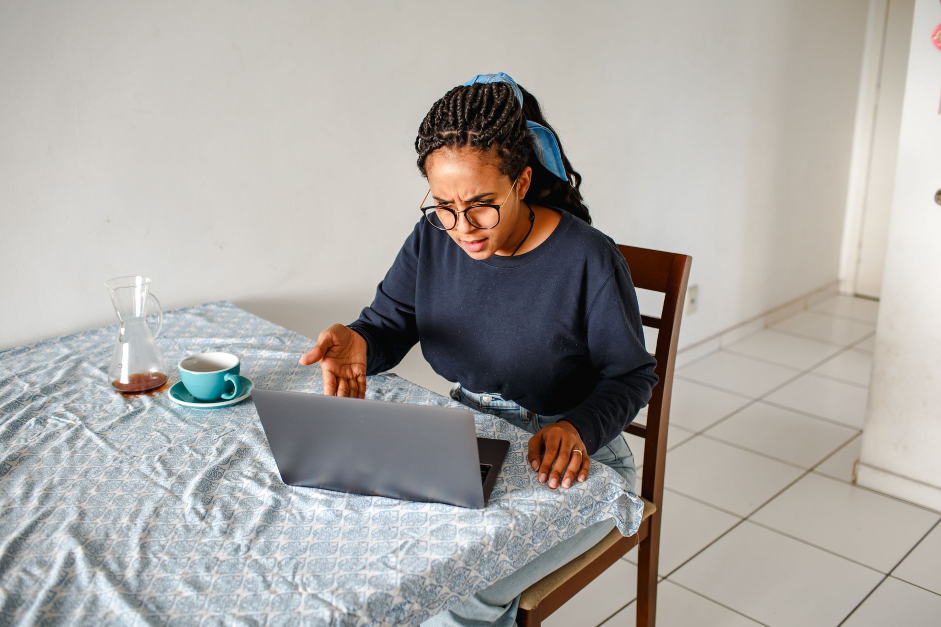 Key worker looking at rental listings on laptop with concerned expression
