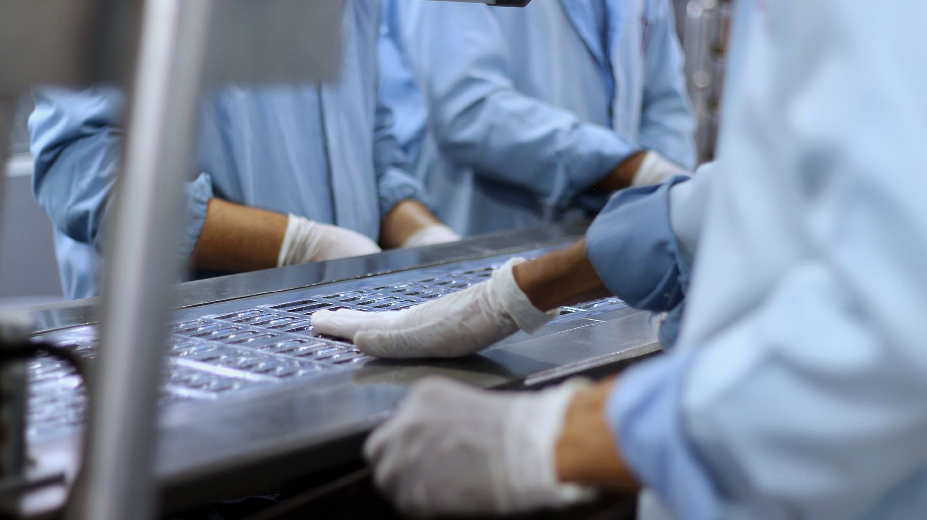 Factory workers assembling modular home components in controlled environment