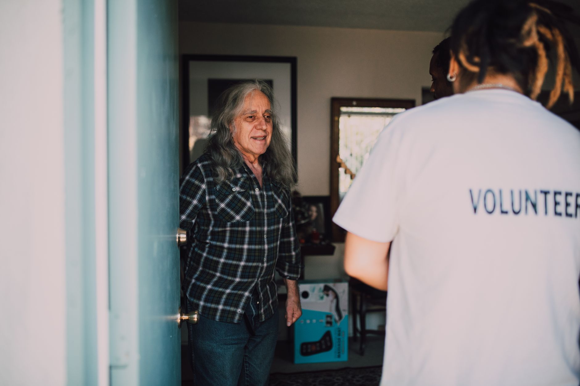 Social worker visiting tenant - alt text: Housing support worker conducting home visit with elderly tenant