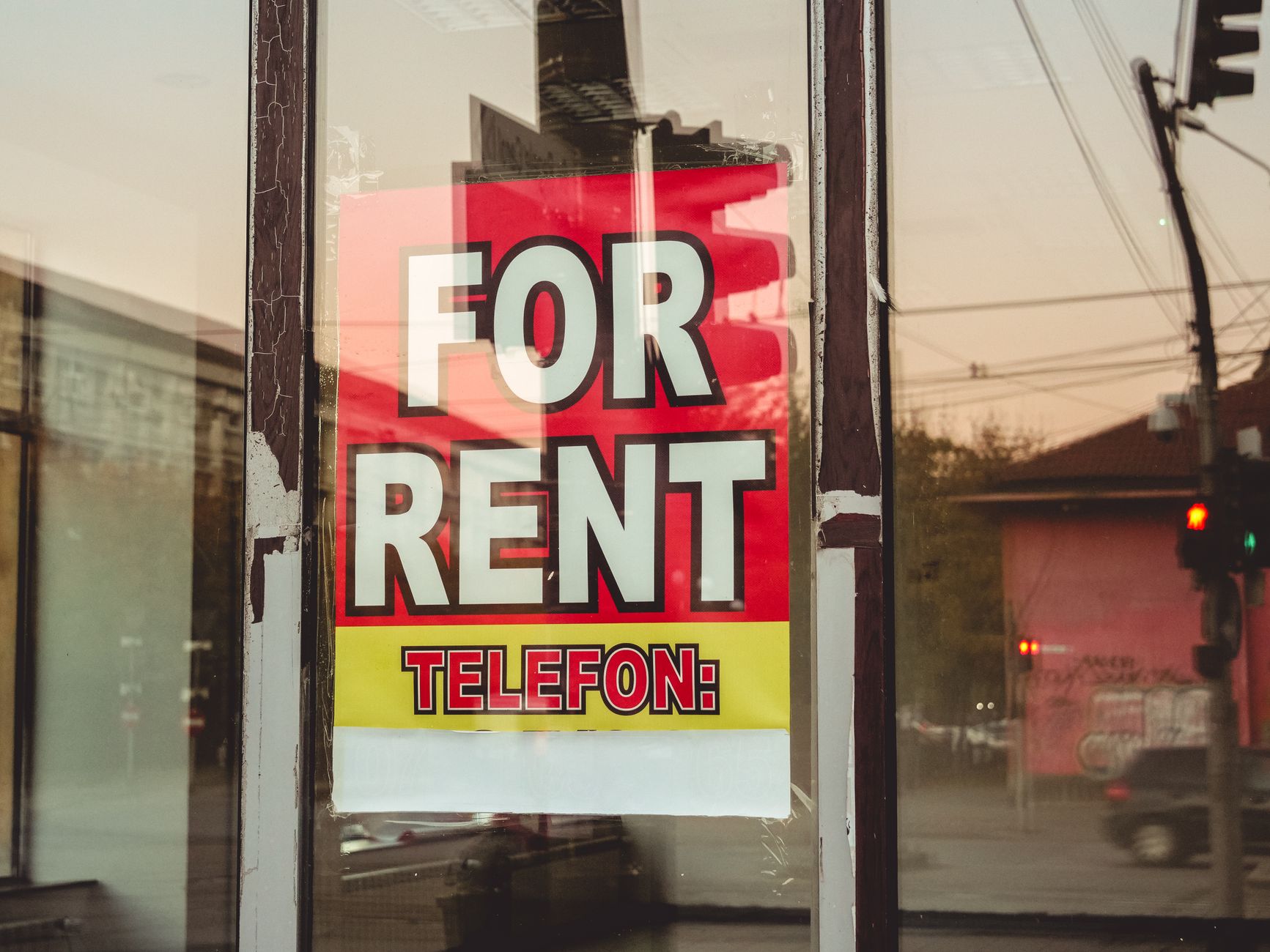 A row of terraced houses with 'For Rent' signs in front