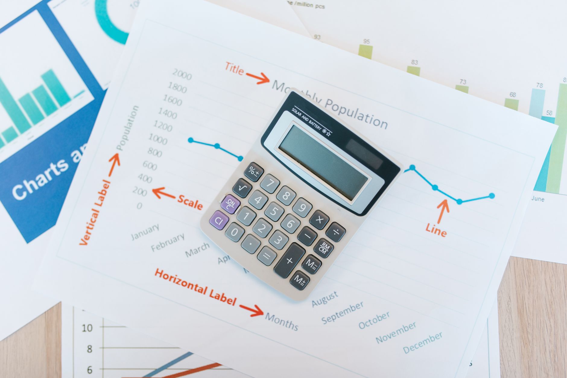 Financial charts and documents with calculator showing housing association budget planning