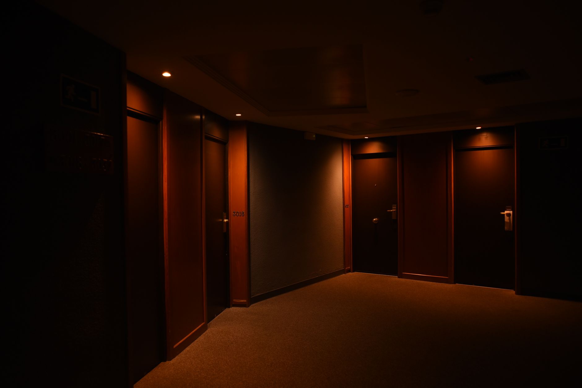 A dimly lit, cramped hotel room or budget B&B interior representing temporary accommodation