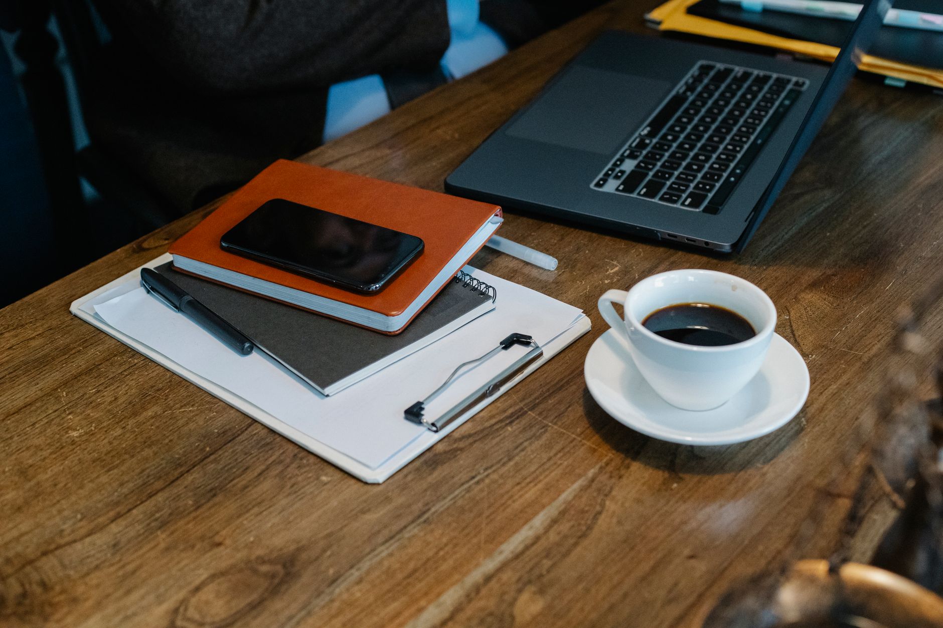 Regulatory documents on a desk with a laptop and coffee cup