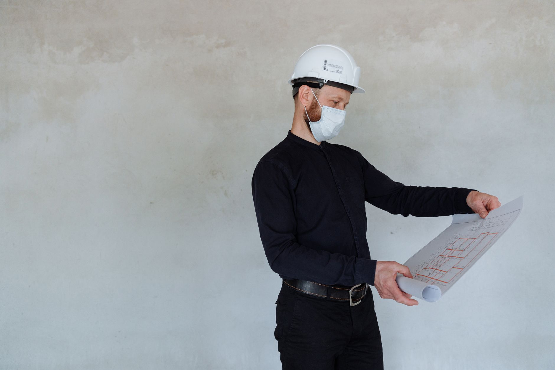 Construction worker reviewing social housing blueprints