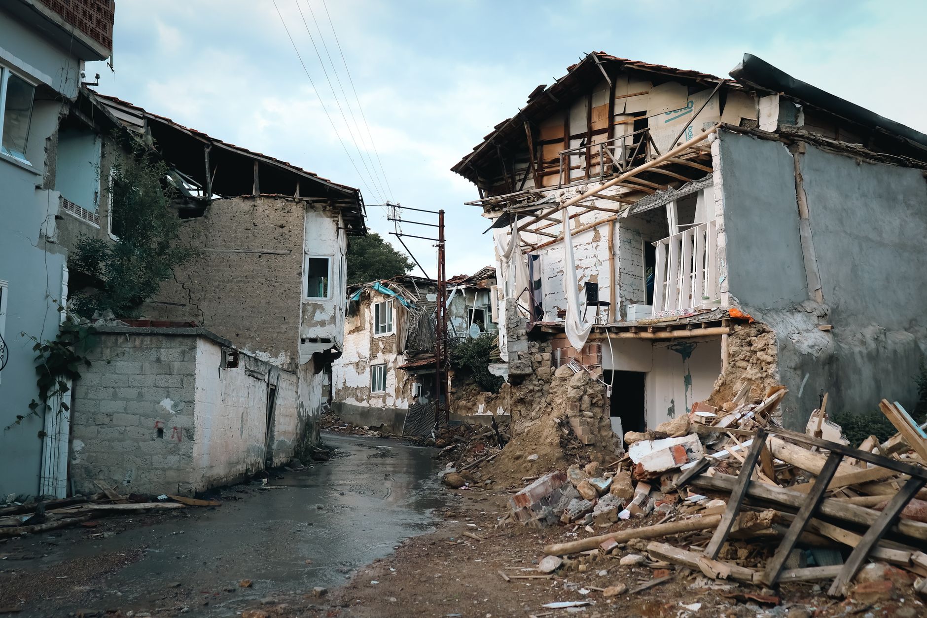 Demolished street with subsidence damage showing cracked pavement and unstable ground