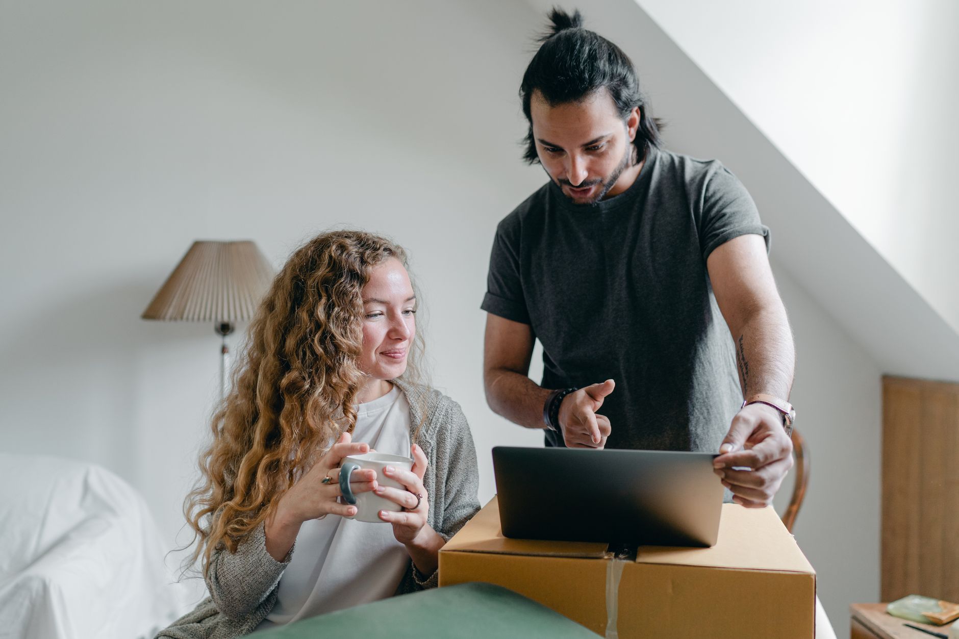Young couple looking at house prices on a laptop - representing housing affordability challenges
