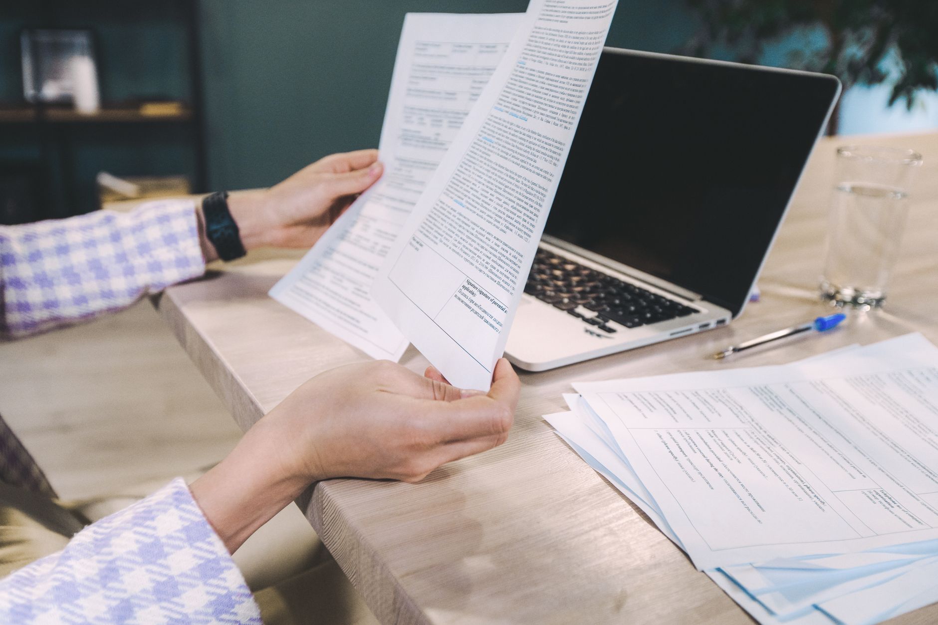 Property manager reviewing rental contracts and market data on a laptop in an office setting