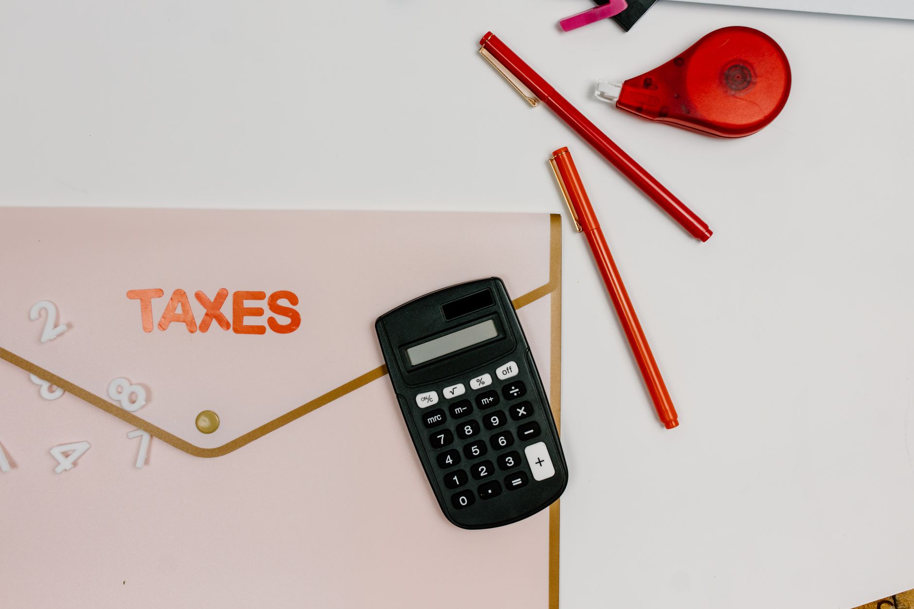 Tax documents and calculator on desk with HMRC logo visible